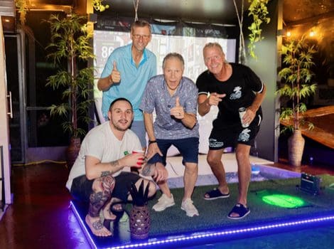 Group of four men posing and smiling.
