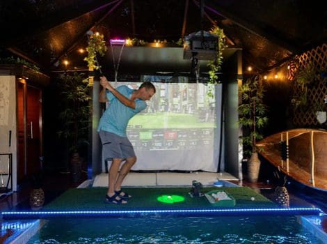 Man playing indoor virtual golf game.