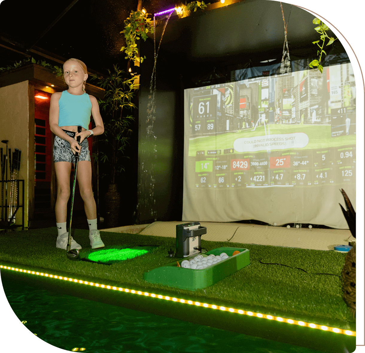 Person golfing in indoor simulation setup.