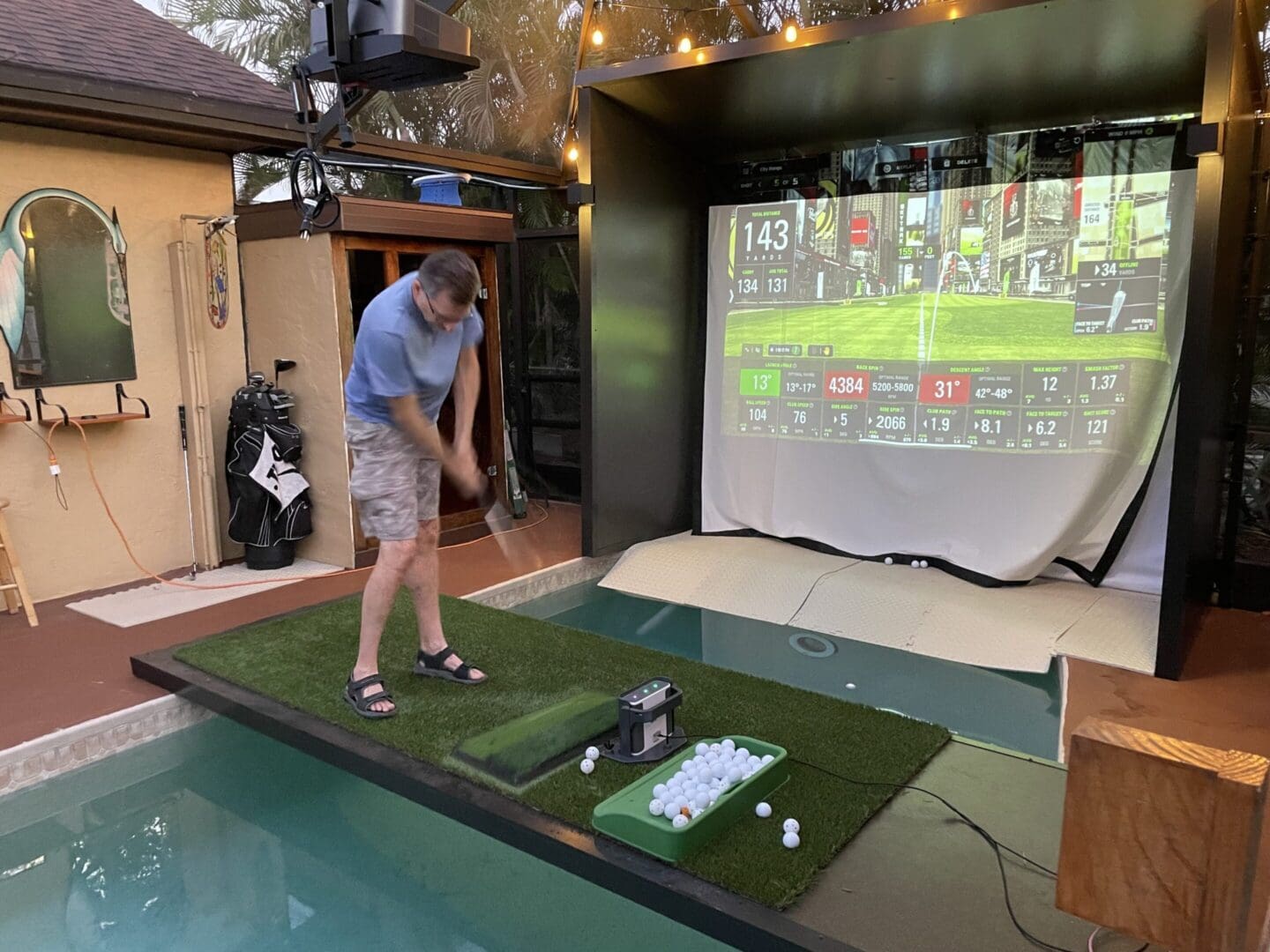 Man playing golf on indoor simulator setup.