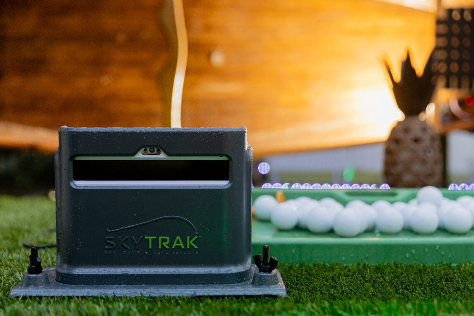 SkyTrak device on grass with golf balls.