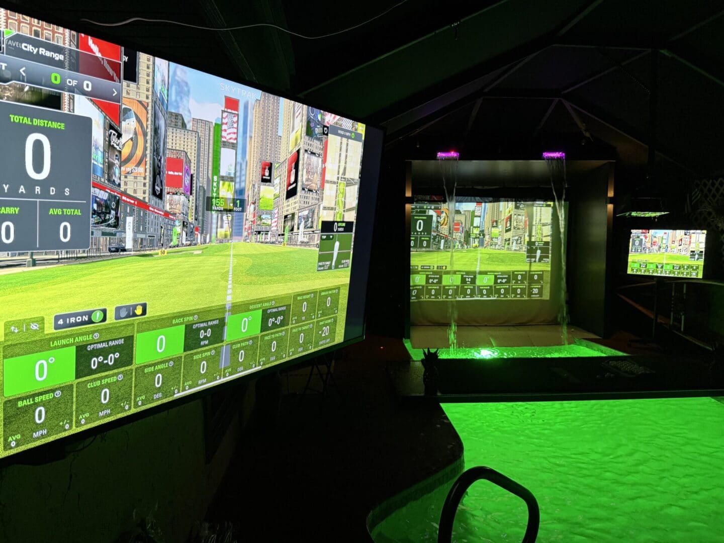 Indoor golf simulator with green lighting.